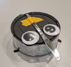 A cute roomba with a knife and googly eyes